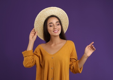 Young woman wearing stylish dress on purple background