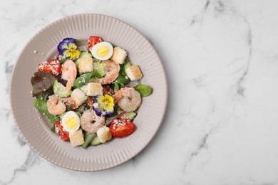 Photo of Delicious Caesar salad with shrimps on white marble table, top view. Space for text