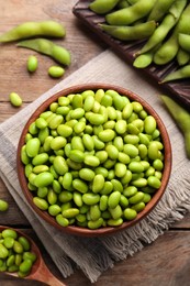 Delicious edamame beans on wooden table, flat lay