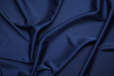 Photo of Crumpled dark blue silk fabric as background, top view