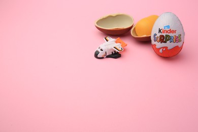 Photo of Sveti Vlas, Bulgaria - June 30, 2023: Kinder Surprise Eggs, plastic capsule and toy on pink background, space for text