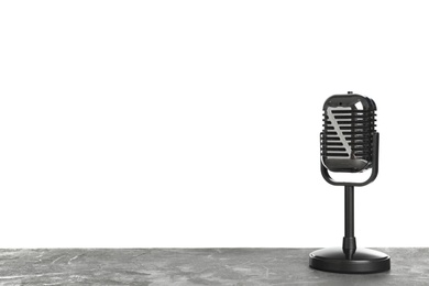 Photo of Retro microphone on table against white background. Space for text