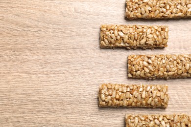 Delicious sweet kozinaki bars on wooden table, flat lay. Space for text