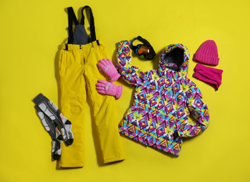 Photo of Stylish winter sport clothes on yellow background, flat lay