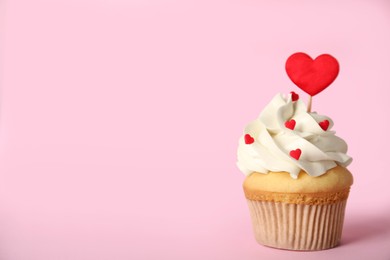 Photo of Tasty cupcake on pink background, space for text. Valentine's Day celebration