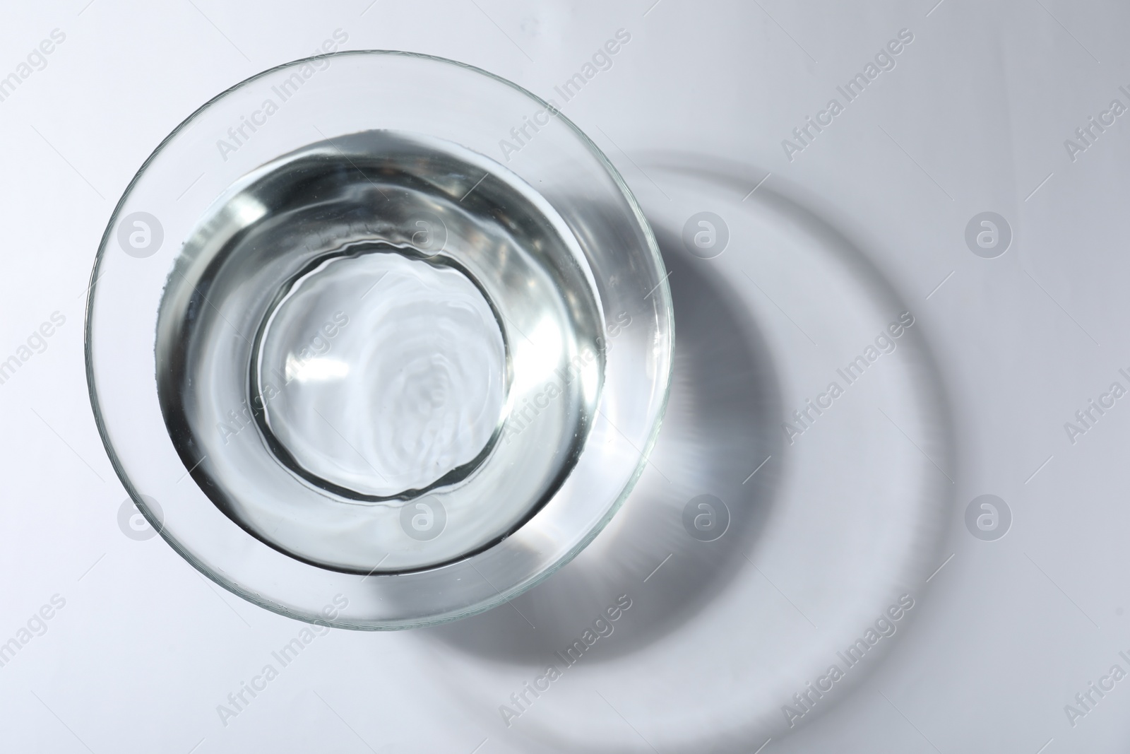 Photo of Glass bowl with water on white background, top view