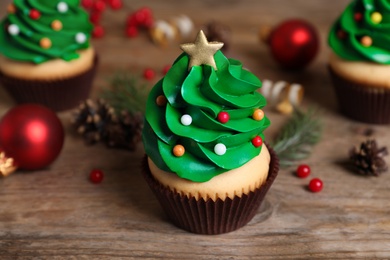 Christmas tree shaped cupcake on wooden table, closeup