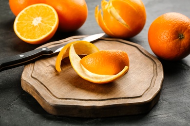 Photo of Orange fruits with peels on wooden board