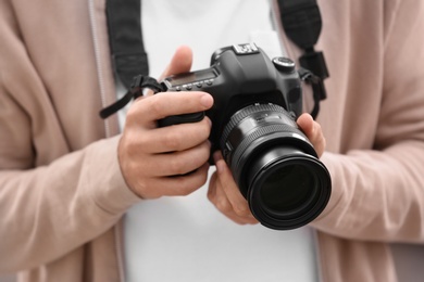 Photo of Male photographer with professional camera, closeup view