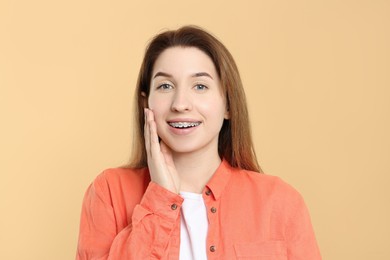 Photo of Portrait of smiling woman with dental braces on beige background