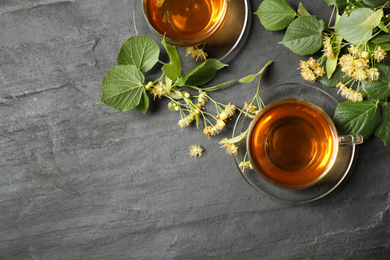 Photo of Flat lay composition with tasty tea and linden blossom on black table. Space for text