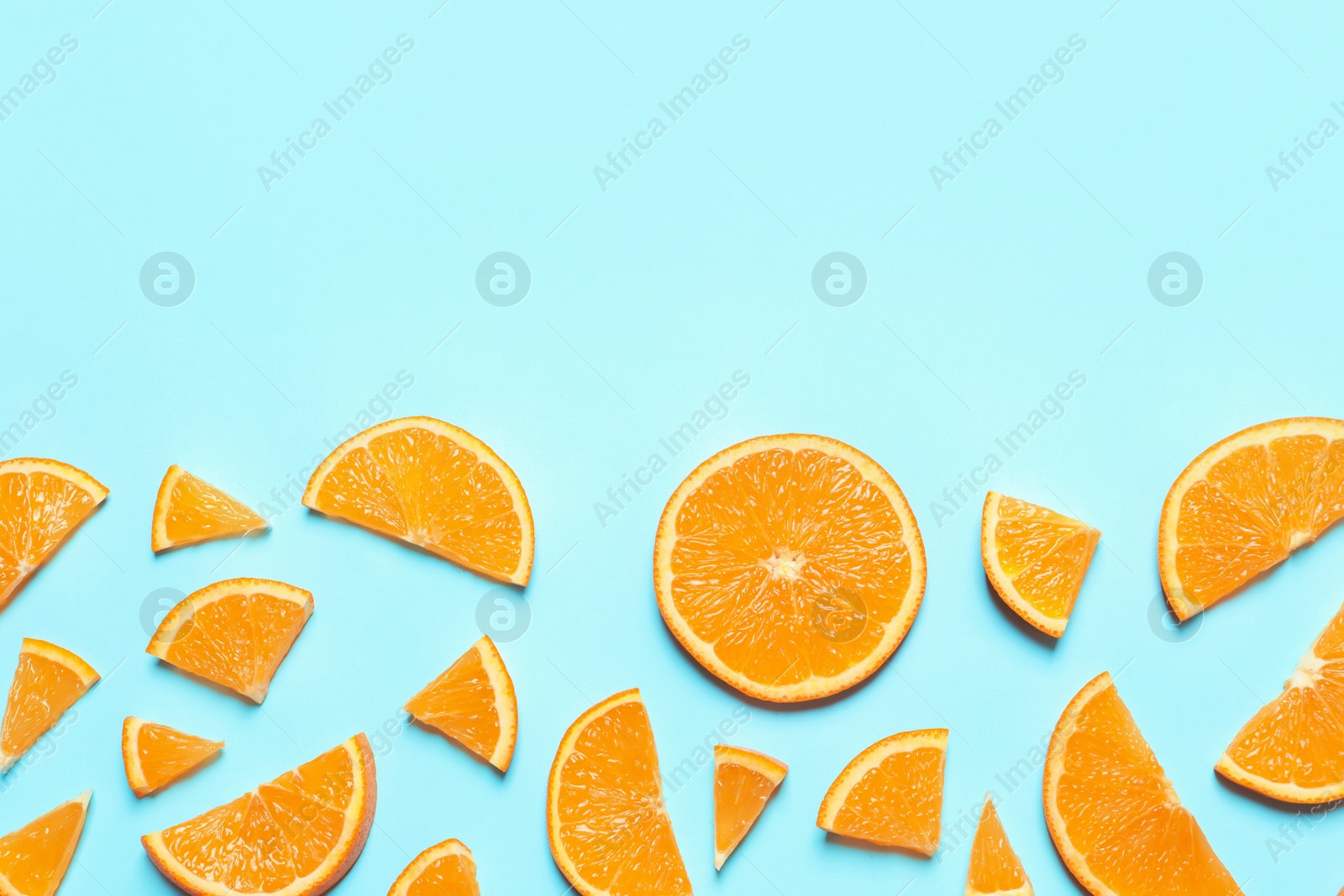 Photo of Flat lay composition with orange slices and space for text on color background