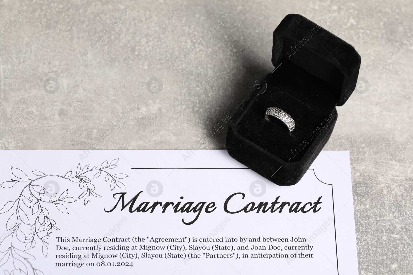 Photo of Marriage contract and ring on grey background
