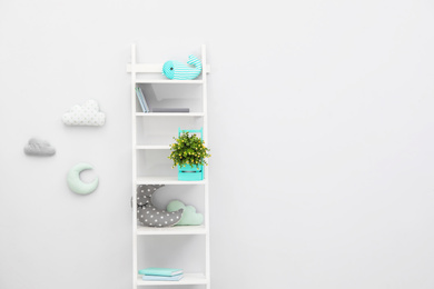 Stylish shelving unit near light wall in child room