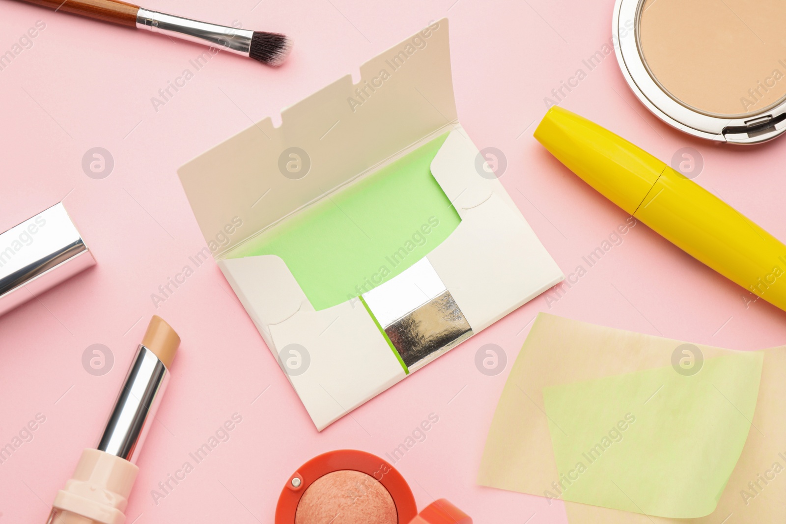 Photo of Flat lay composition with facial oil blotting tissues and makeup products on pink background. Mattifying wipes