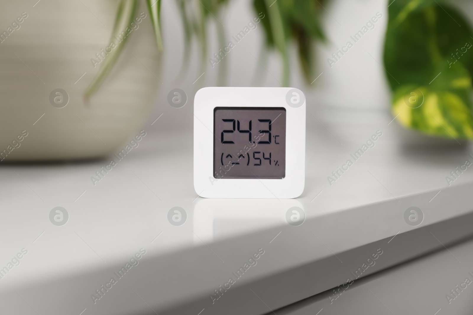 Photo of Digital hygrometer with thermometer on white table