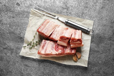 Photo of Raw ribs with thyme on grey table, flat lay