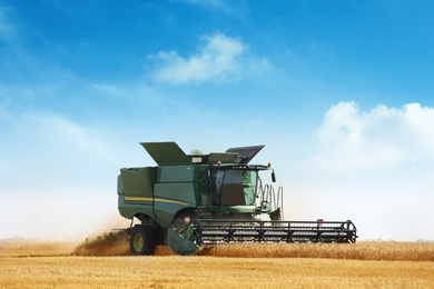 Modern combine harvester working in agricultural field