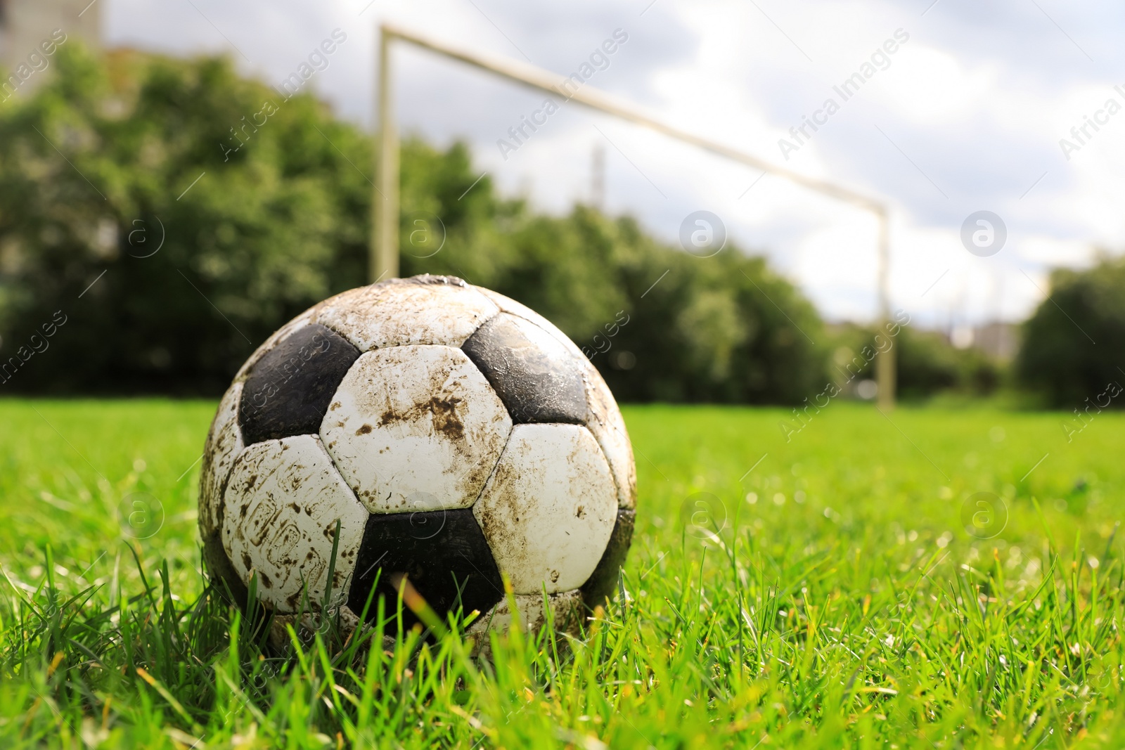 Photo of Dirty soccer ball on green grass outdoors, space for text