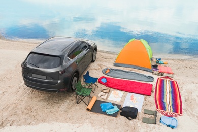 Car and camping equipment on sandy beach. Summer trip