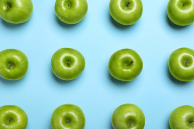 Photo of Tasty green apples on light blue background, flat lay