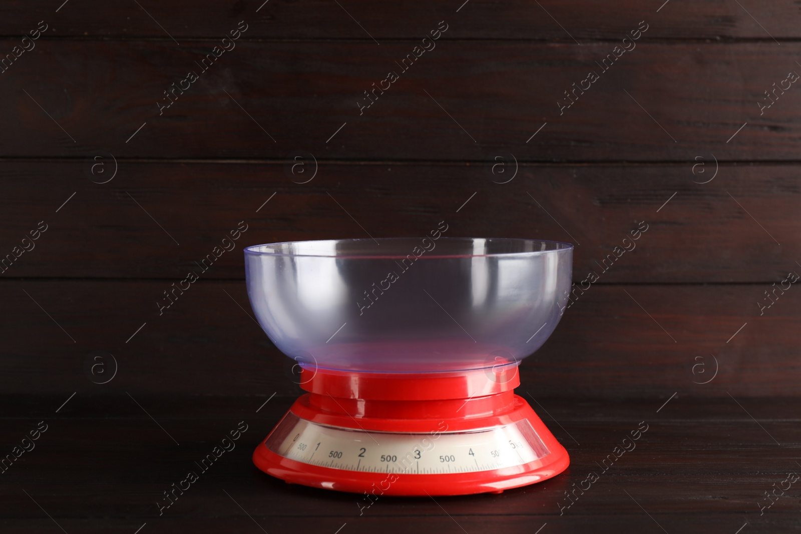 Photo of Kitchen scale with plastic bowl on wooden table