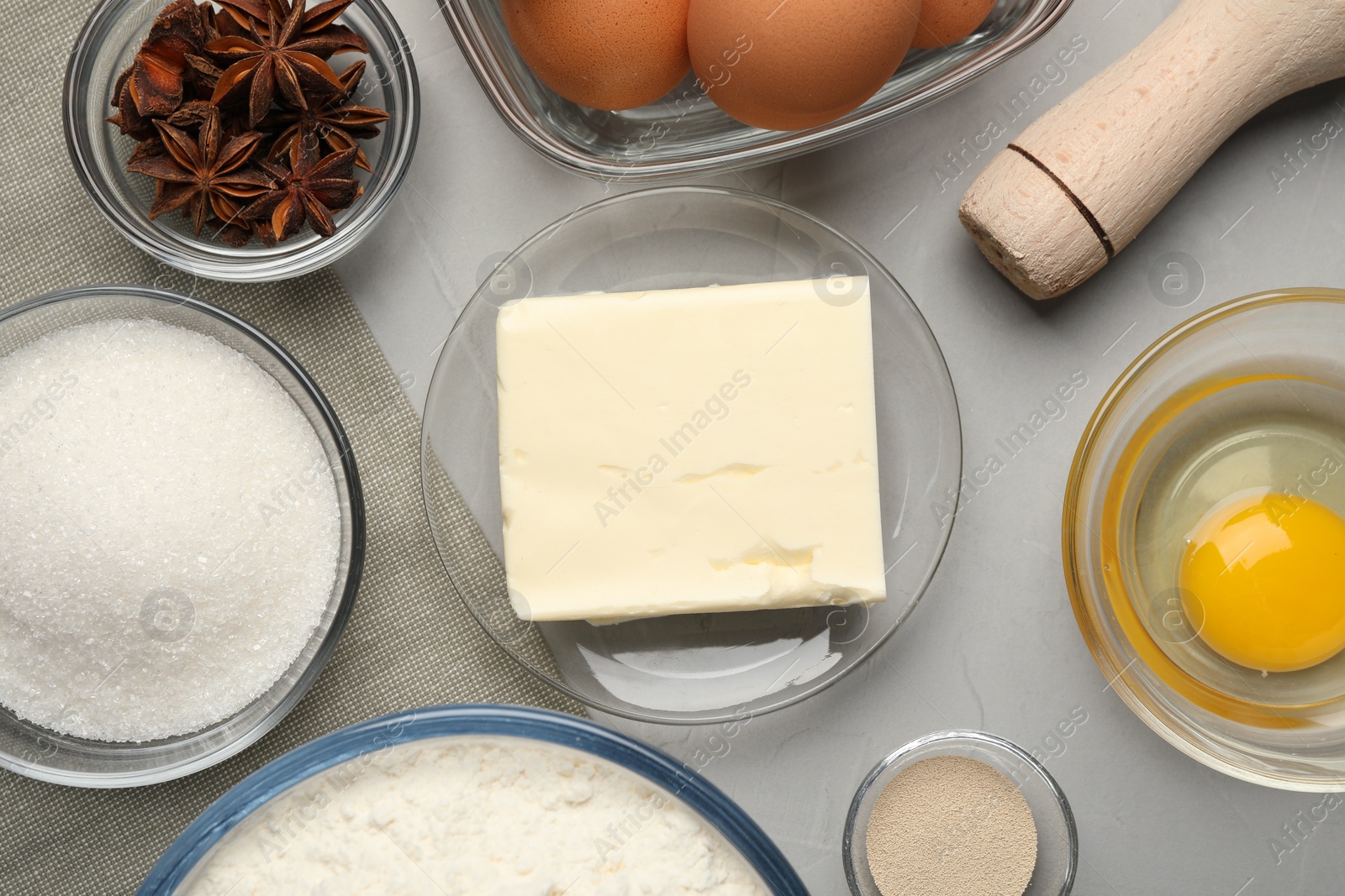 Photo of Flat lay composition with flour, butter and different ingredients on light grey table. Cooking yeast cake