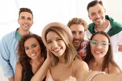 Group of happy young people taking selfie indoors