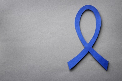 Photo of Blue awareness ribbon on grey background, top view with space for text. Symbol of social and medical issues