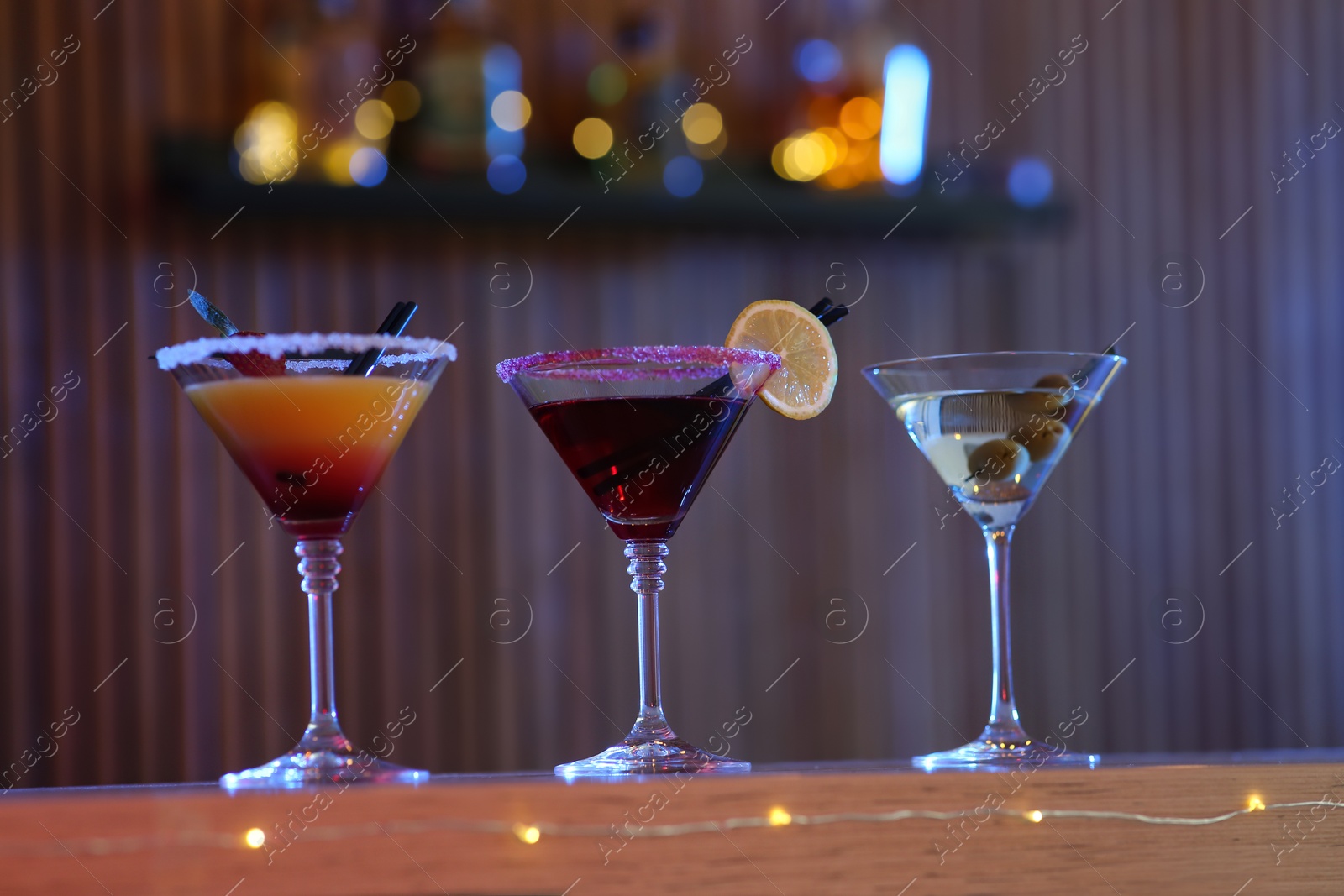 Photo of Different martini cocktails on table in bar