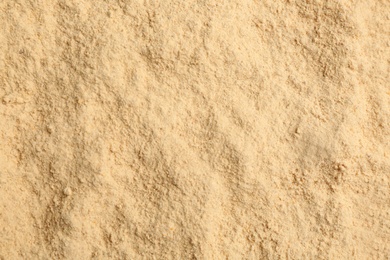 Photo of Dry powdered ginger as background, top view