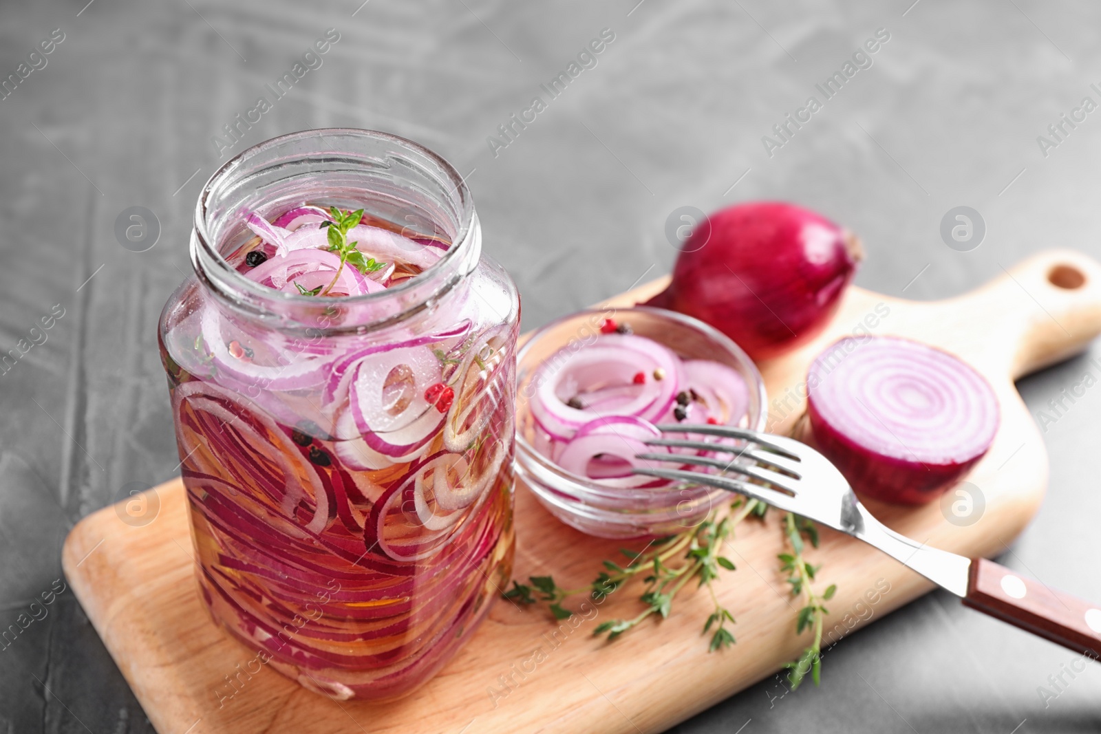 Photo of Jar of pickled onions on grey table