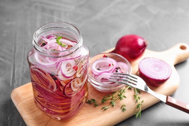 Photo of Jar of pickled onions on grey table