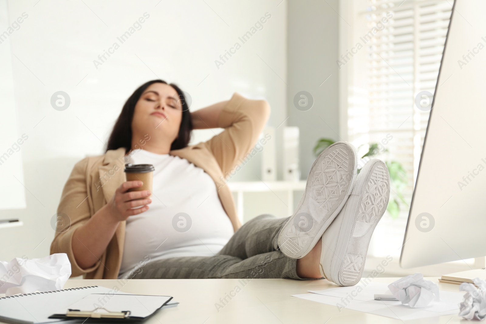 Photo of Lazy overweight worker at white desk in office