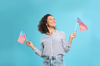 happy young woman with American flags on blue background