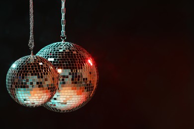 Photo of Shiny bright disco balls on dark background, space for text