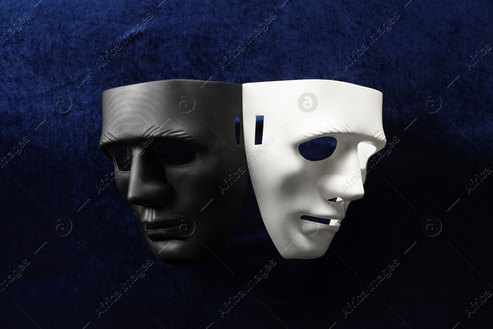 Photo of Theater arts. Two masks on blue fabric, top view