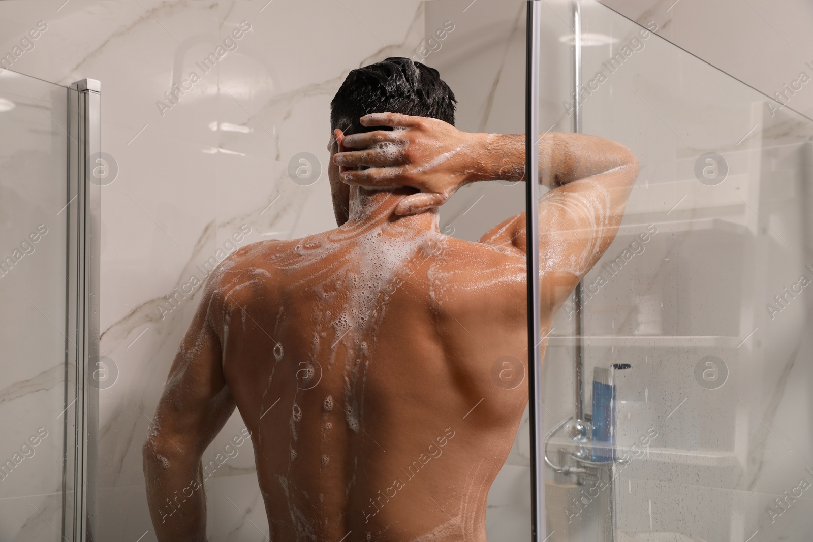 Photo of Man taking shower with gel at home