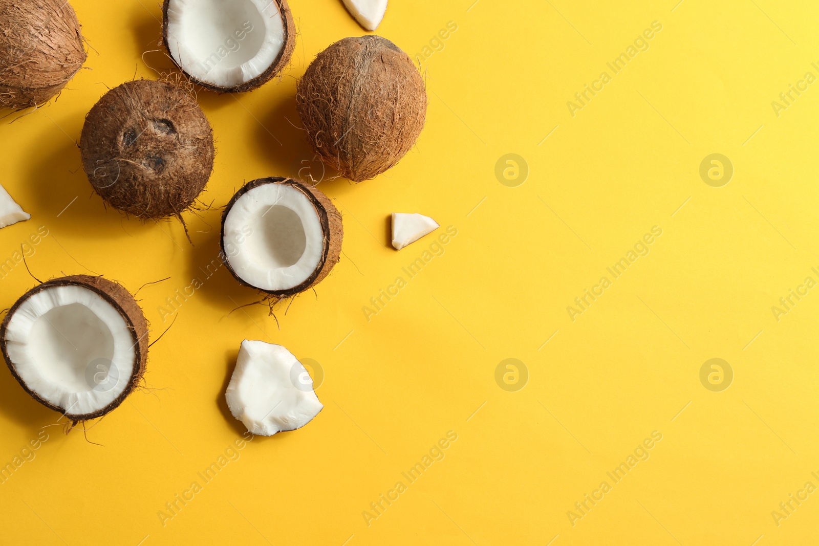 Photo of Flat lay composition with coconuts on color background. Space for text