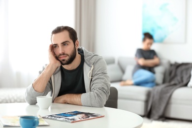 Photo of Young couple ignoring each other after having argument in living room