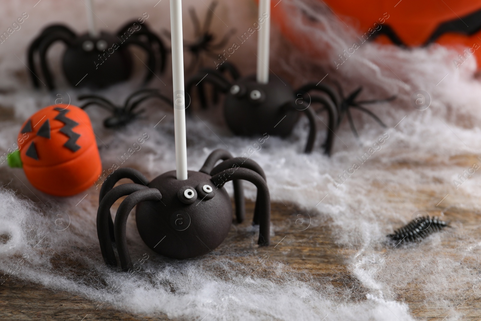 Photo of Different Halloween themed cake pops on wooden table, closeup