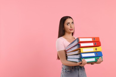 Disappointed woman with folders on pink background, space for text
