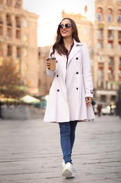 Photo of Beautiful woman walking along street on autumn day