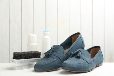 Photo of Stylish footwear with shoe care accessories on white  table
