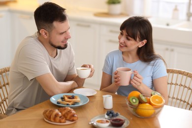 Photo of Happy couple having tasty breakfast at home