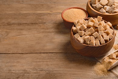 Different types of sugar on wooden table, space for text