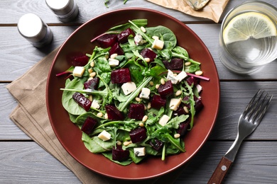 Fresh delicious beet salad on grey wooden table, flat lay