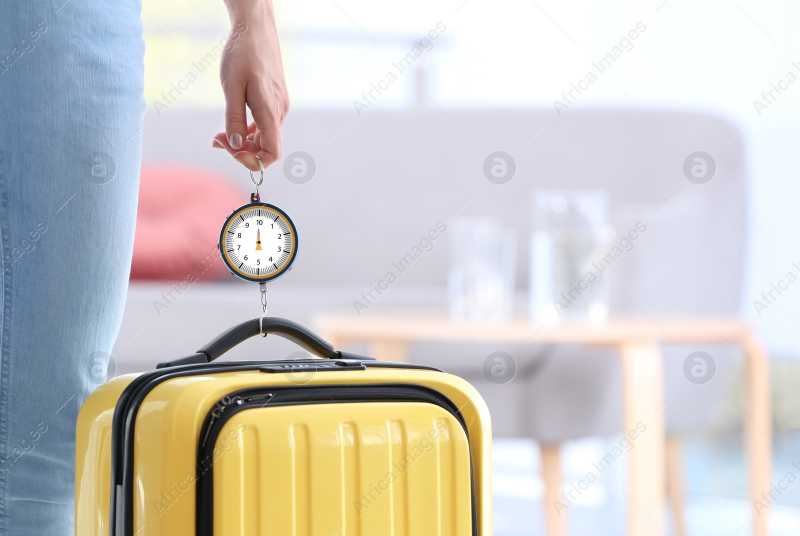 Photo of Woman weighing suitcase indoors, closeup. Space for text