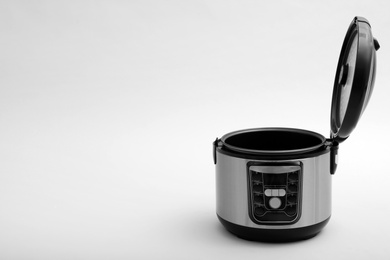 Photo of Modern electric multi cooker on light background. Space for text