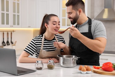 Lovely young couple cooking together in kitchen